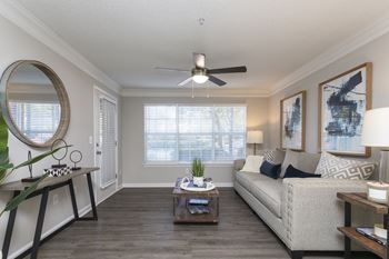 A living room with a ceiling fan and a large window